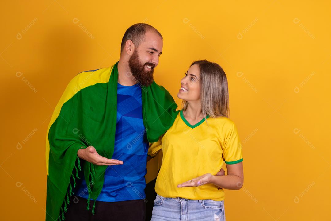 Casal jovem torcedores brasileiros com chapeu do brasil