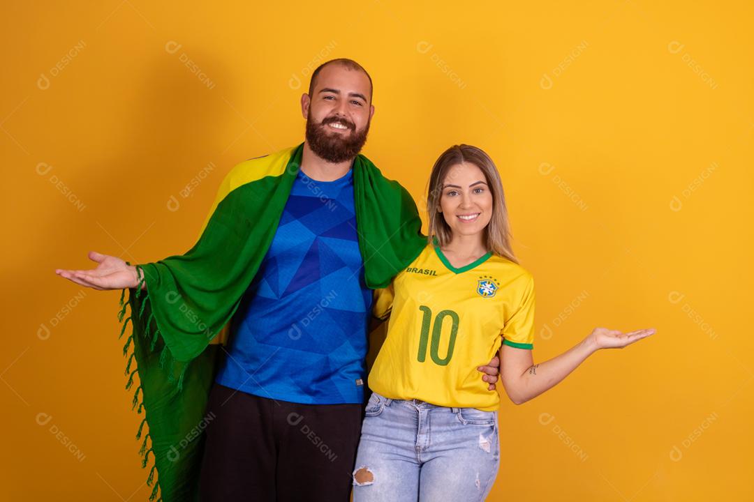 Casal jovem torcedores brasileiros com chapeu do brasil