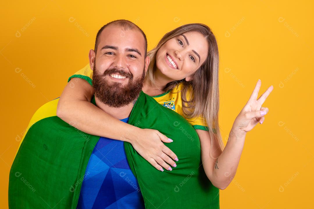 Casal jovem torcedores brasileiros com chapeu do brasil