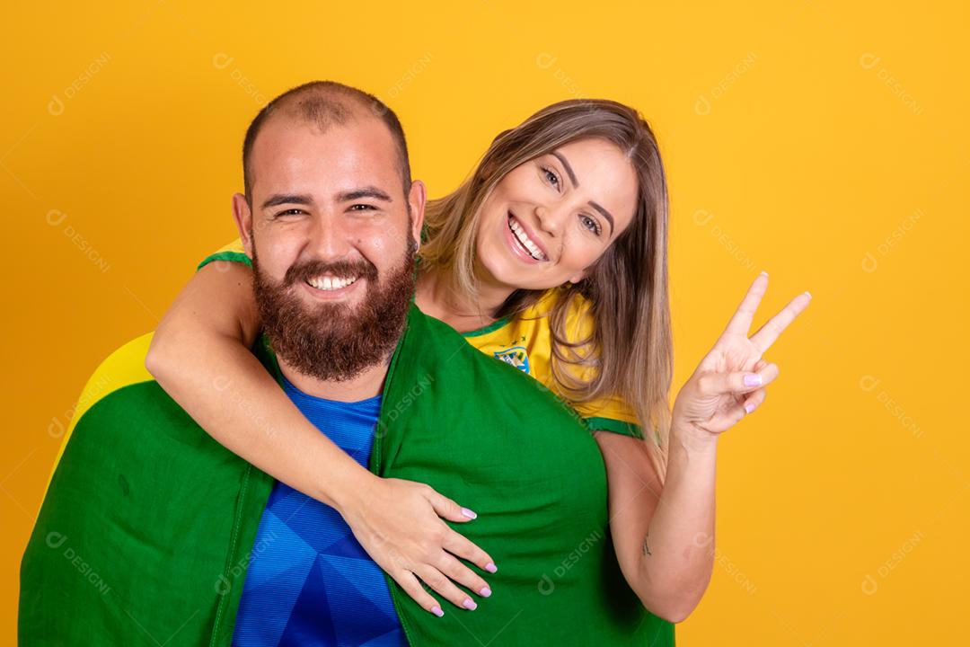 Casal jovem torcedores brasileiros com chapeu do brasil