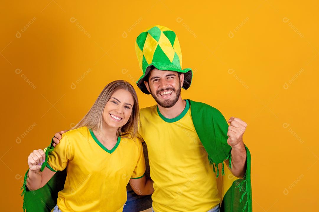 Casal jovem torcedores brasileiros com chapeu do brasil