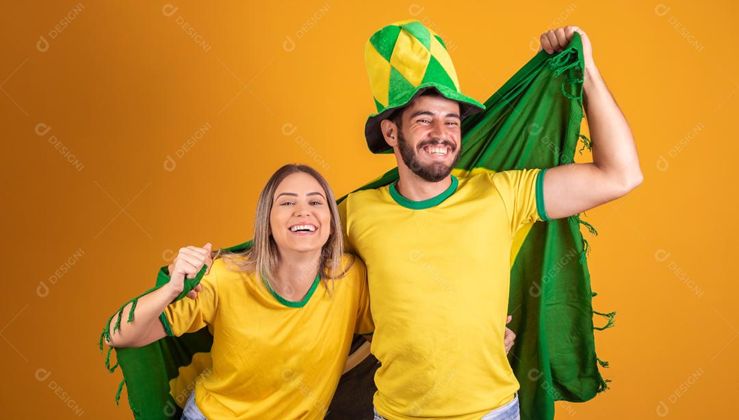 Casal jovem torcedores brasileiros com chapeu do brasil