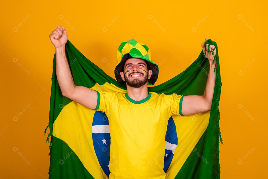 Homem jovem torcedor brasileiro com bandeira do brasil