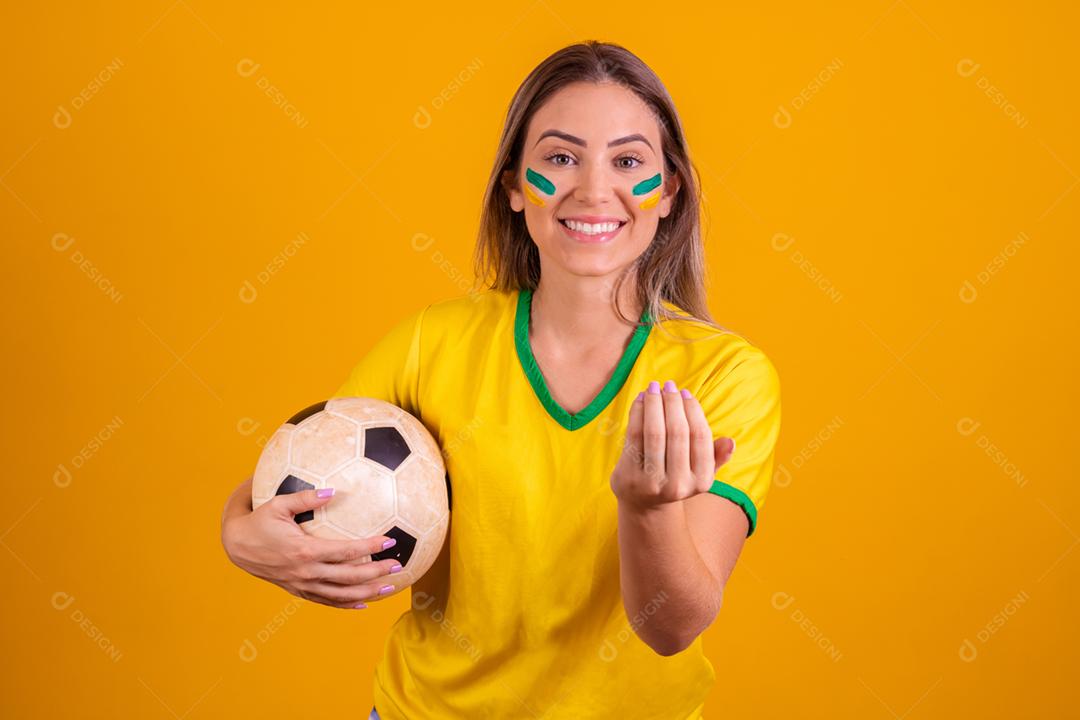 Mulher jovem torcedora brasileira com uma bola de futebol