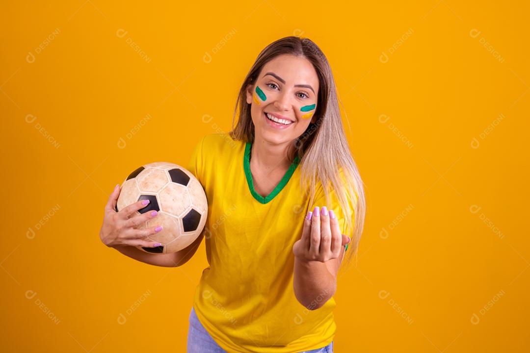 Mulher jovem torcedora brasileira com uma bola de futebol