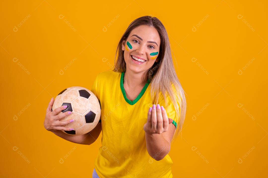 Mulher jovem torcedora brasileira com uma bola de futebol