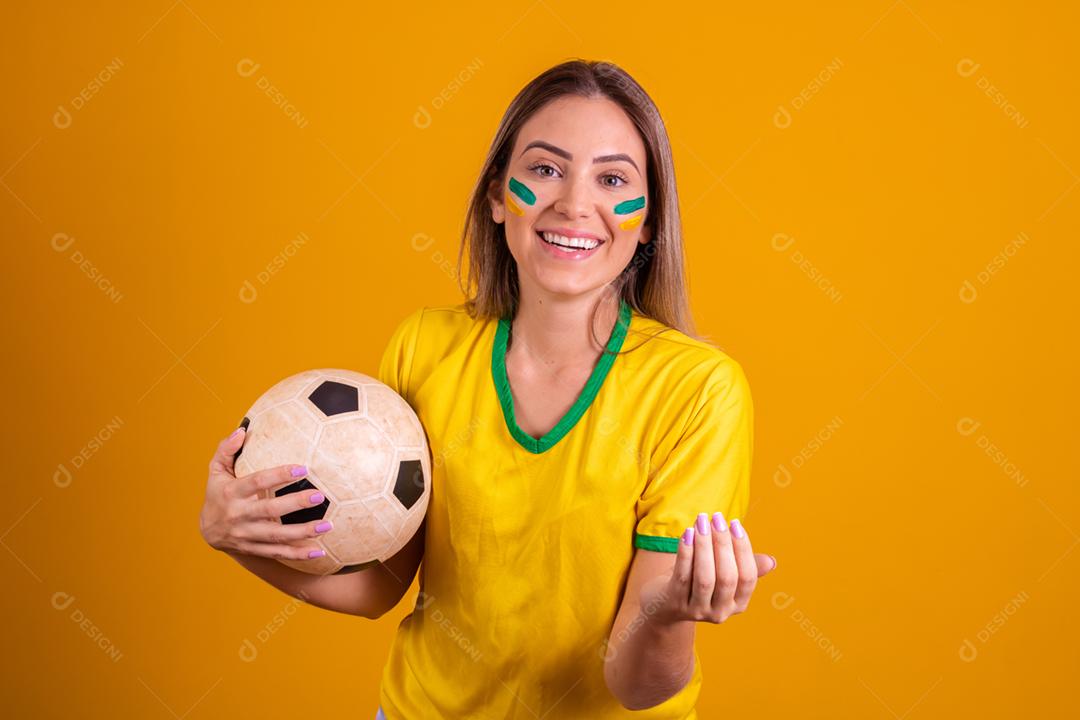 Mulher jovem torcedora brasileira com uma bola de futebol