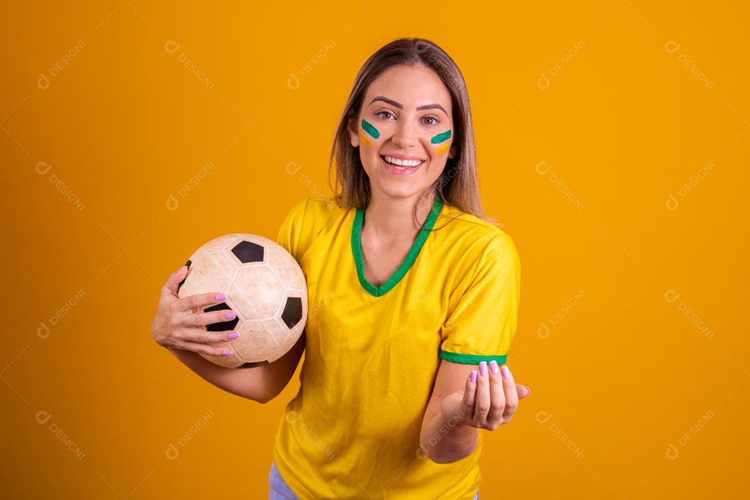 Mulher jovem torcedora brasileira com uma bola de futebol