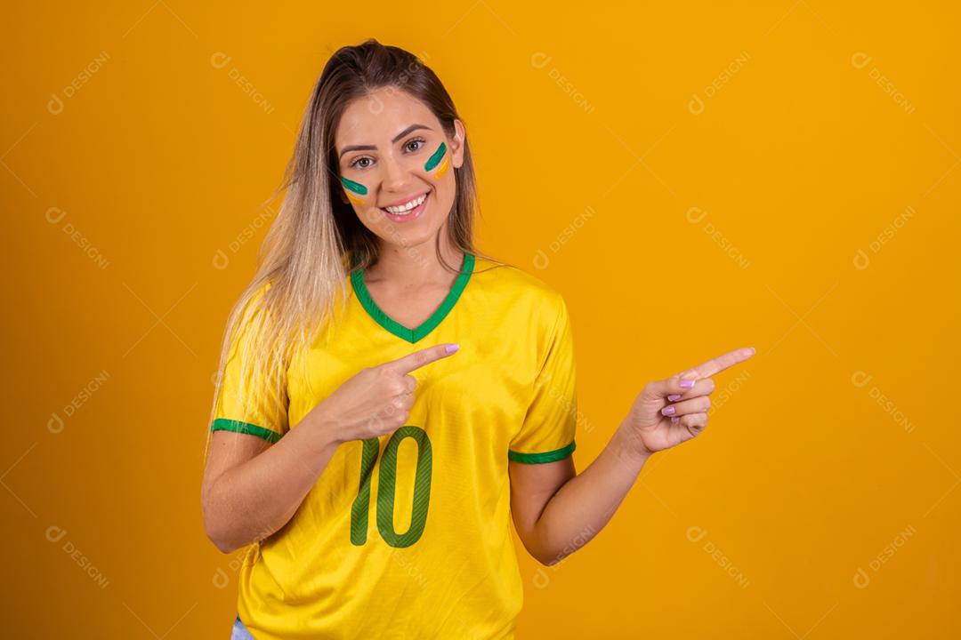Mulher jovem torcedora brasileira com uma bola de futebol