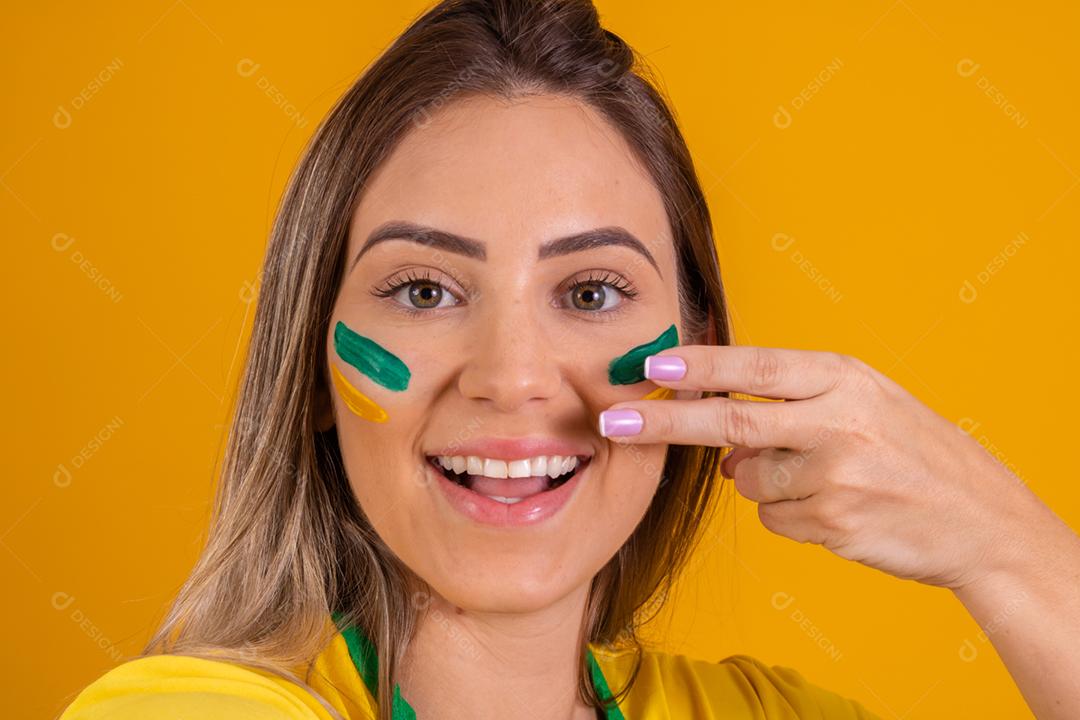 Mulher jovem torcedora brasileira com uma bola de futebol