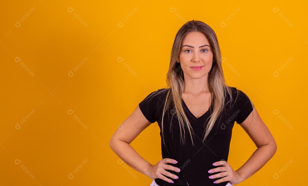 mulher branca loira vestido uma blusa preta em fundo amarelo