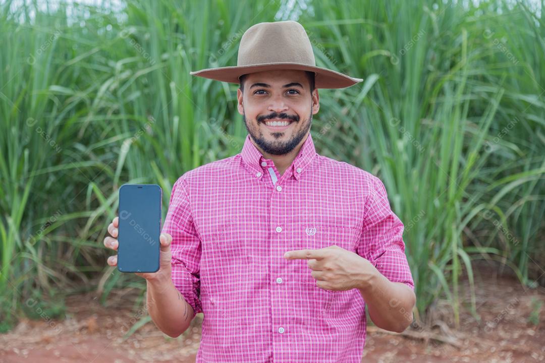 Homem agricultor segurando um smartphone