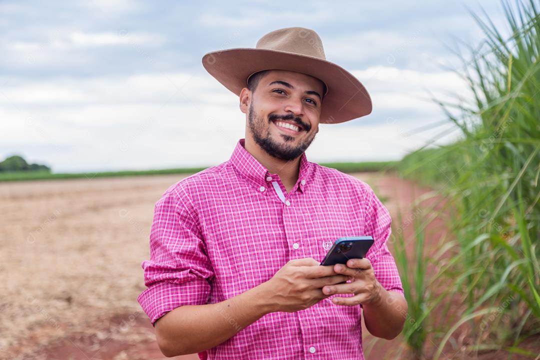 Homem agricultor segurando um smartphone