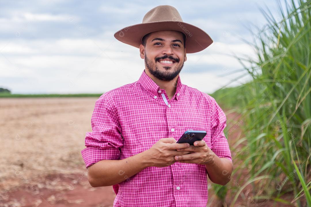 Homem agricultor segurando um smartphone