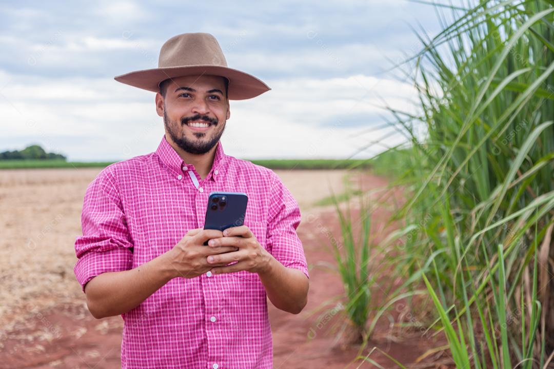 Homem agricultor segurando um smartphone