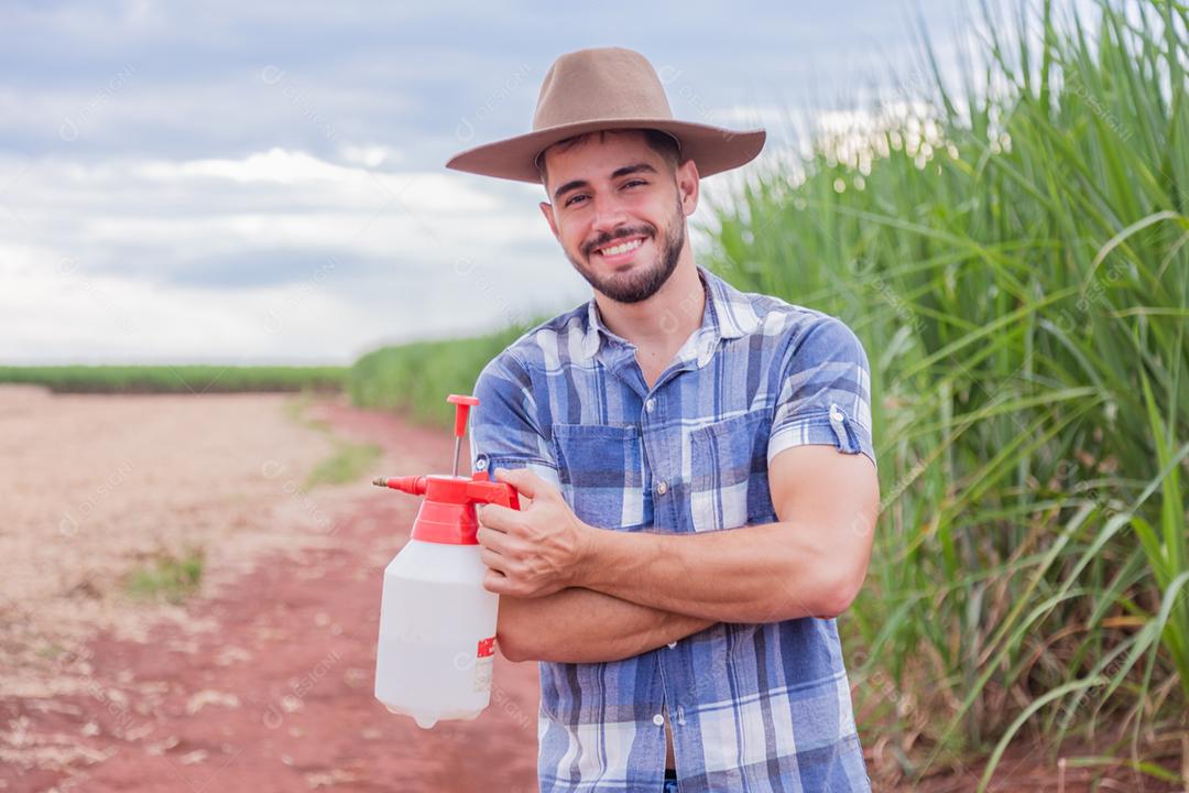 Homem agricultor batendo veneno na plantação