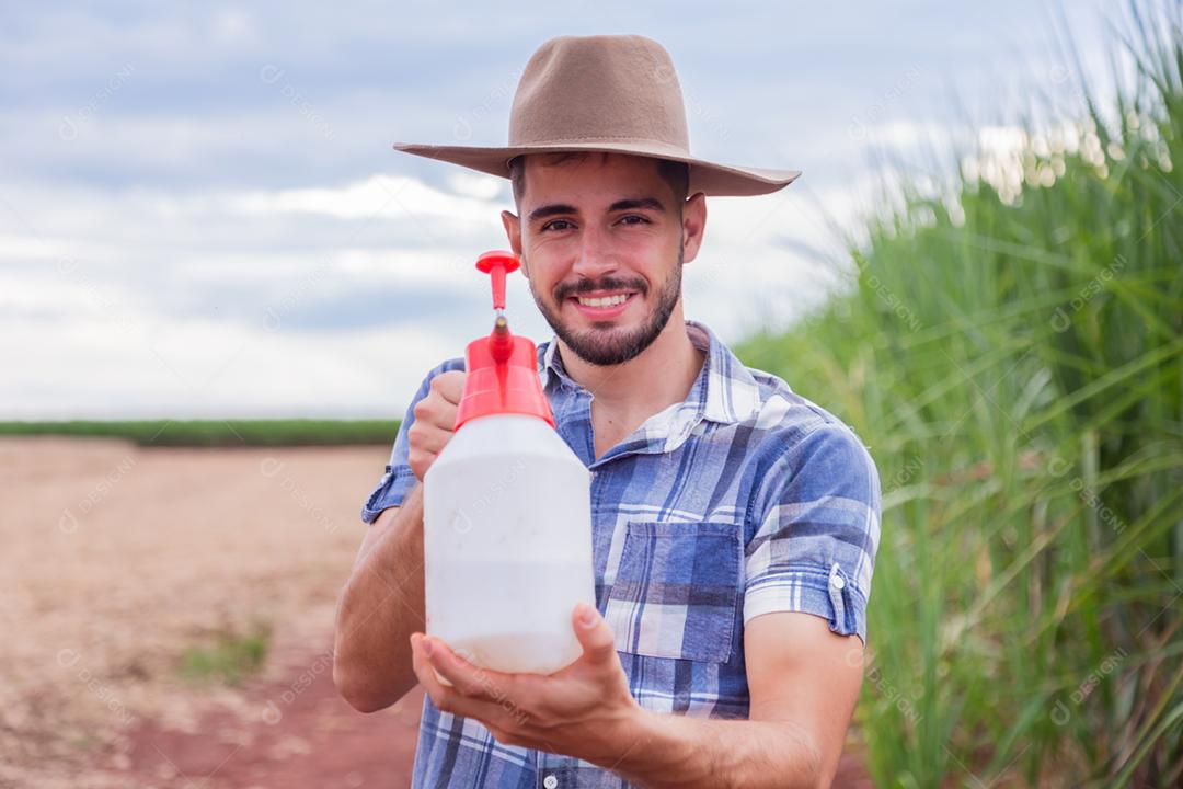 Homem agricultor batendo veneno na plantação