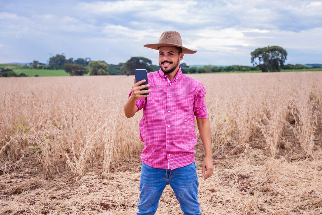 Homem agricultor segurando um smartphone