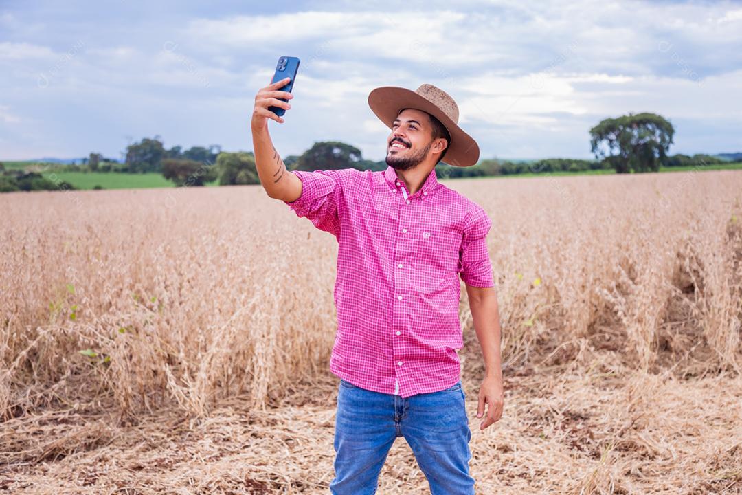 Homem agricultor segurando um smartphone
