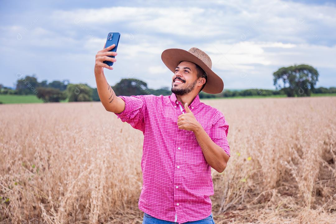 Homem agricultor segurando um smartphone