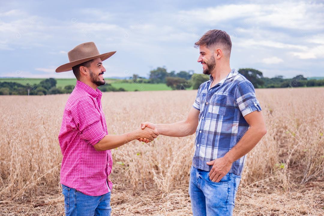 Homens jovens agricultores apertando as mãos