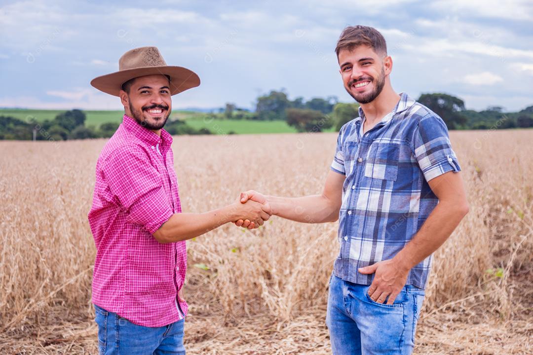 Homens jovens agricultores apertando as mãos
