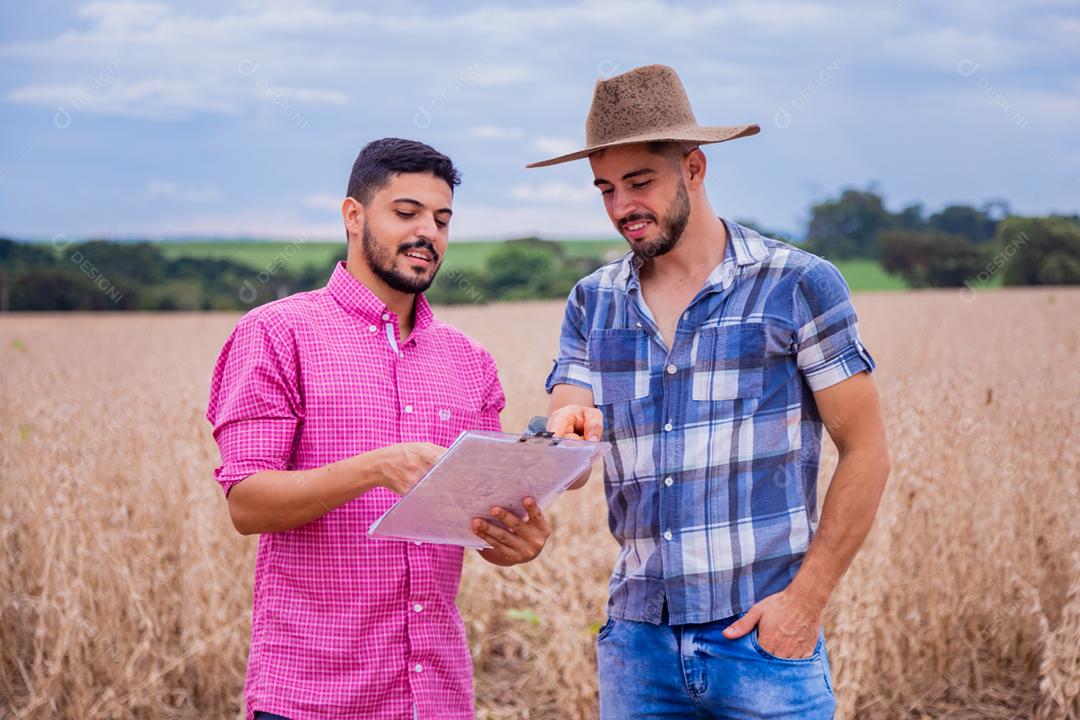 Homens jovens agricultores olhando um projeto no papel