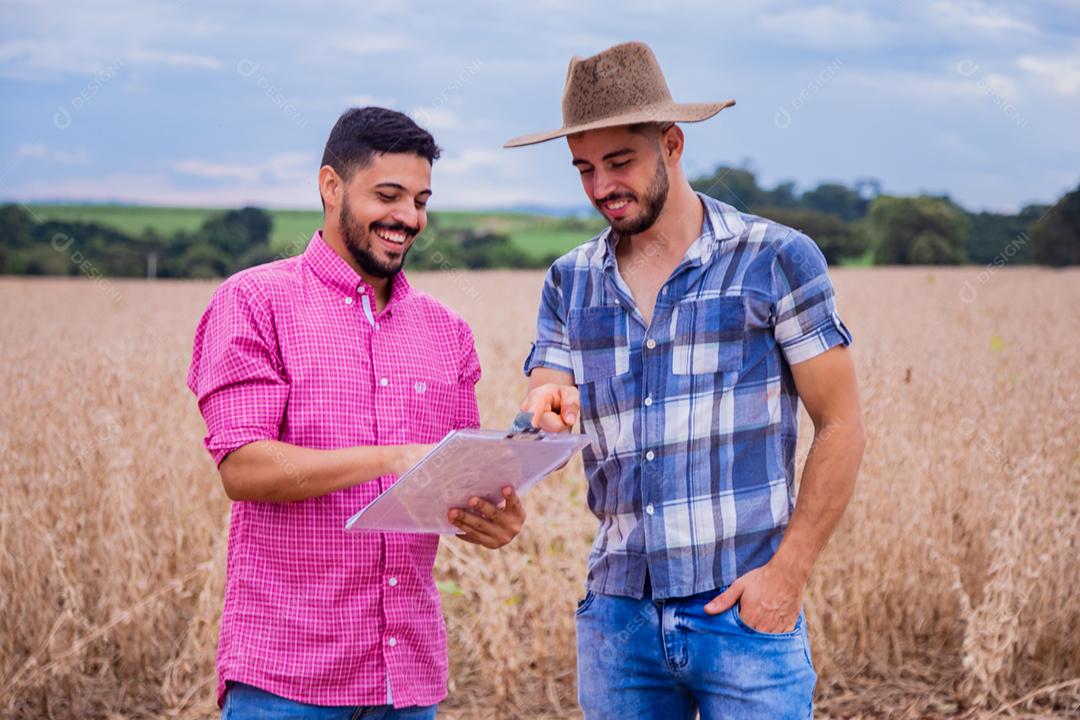 Homens jovens agricultores olhando um projeto no papel