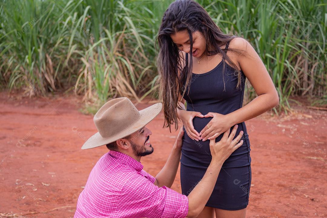 Casal jovem no campo a espera de um bebê