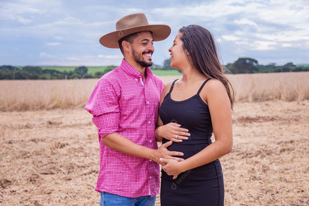 Casal jovem no campo a espera de um bebê