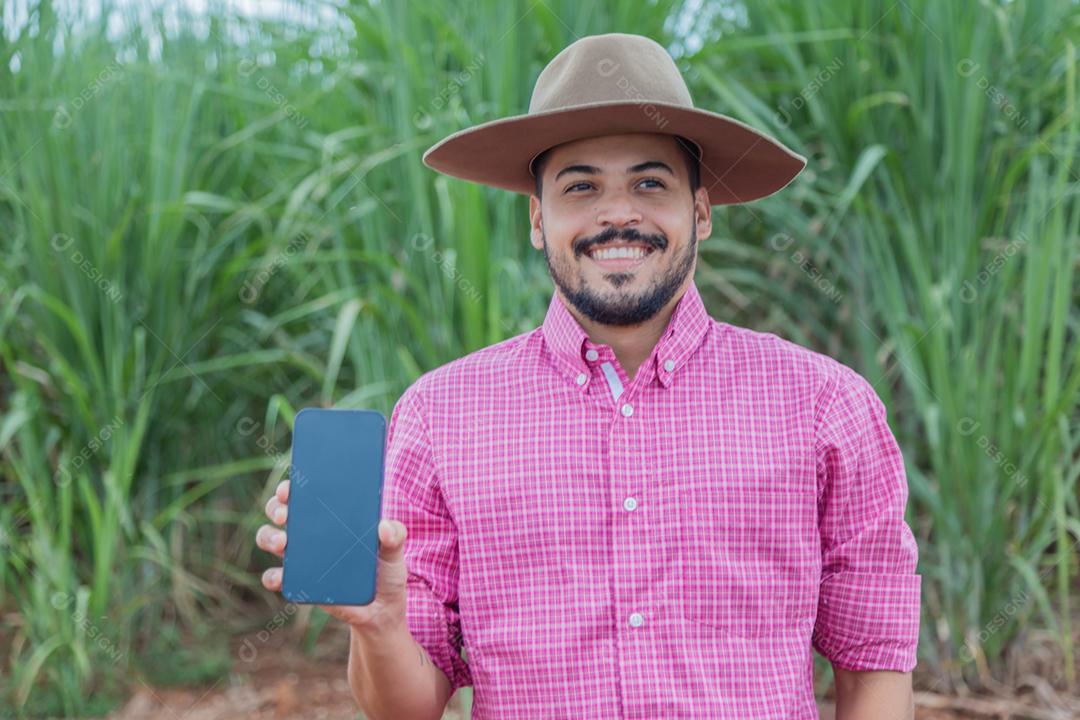 Homem agricultor segurando um smartphone