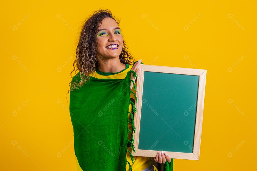 Fã brasileiro segurando uma lousa em branco para espaço de texto. mundo