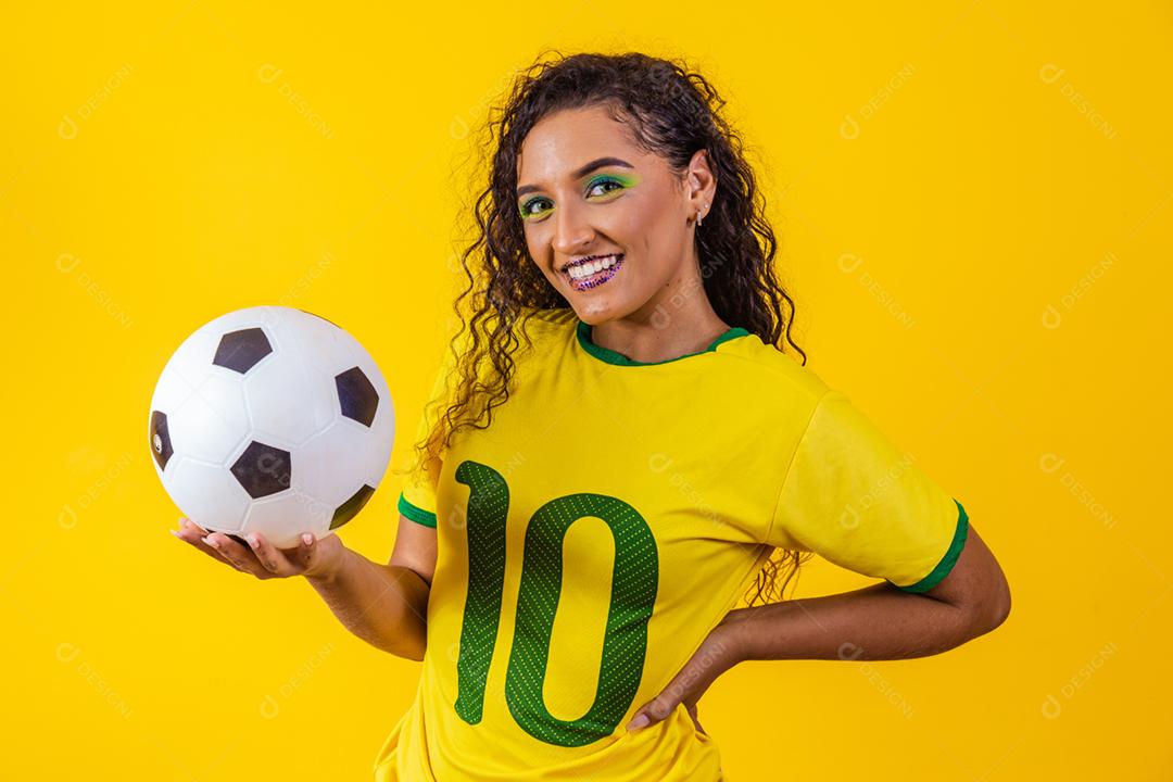 bela torcedora brasileira com uma bola de futebol em amarelo