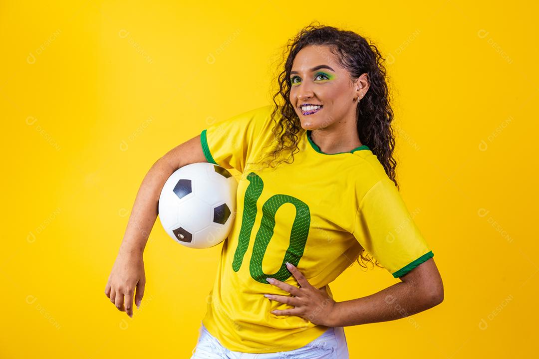 bela torcedora brasileira com uma bola de futebol em amarelo
