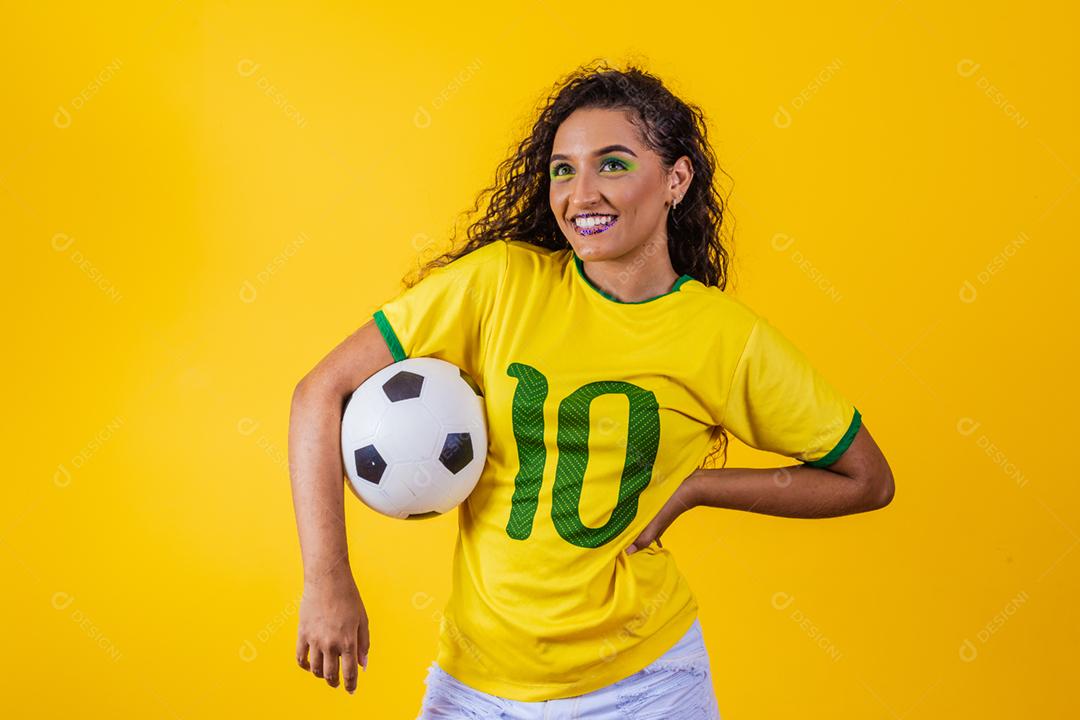 bela torcedora brasileira com uma bola de futebol em amarelo
