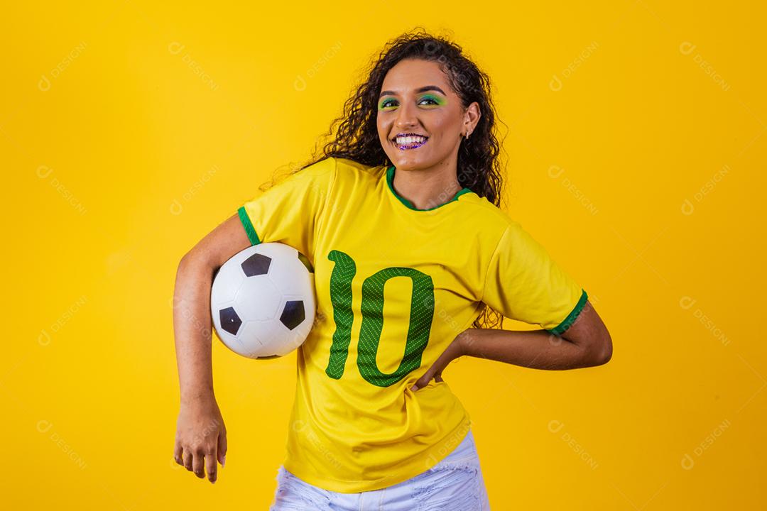 bela torcedora brasileira com uma bola de futebol em amarelo