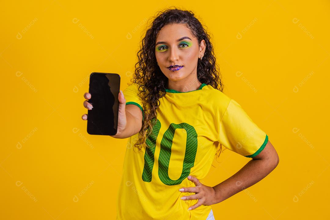 fã brasileiro segurando um smartphone com espaço de cópia