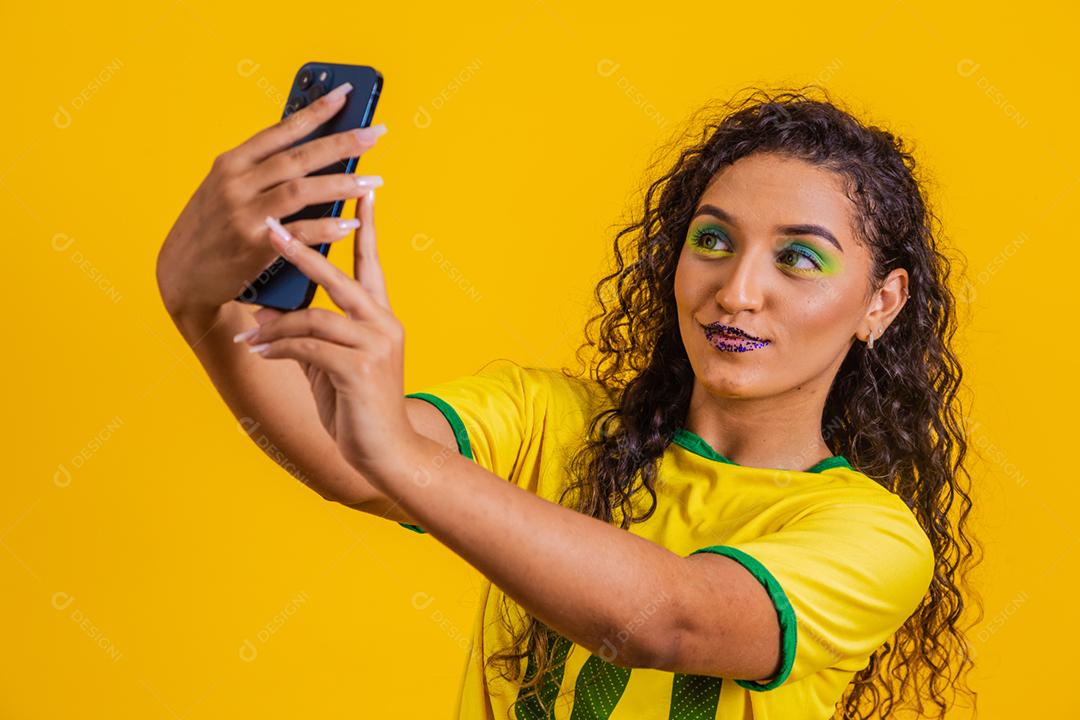 fã brasileiro segurando um smartphone com espaço de cópia