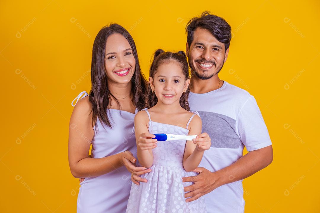 Futura irmã mais velha segurando um teste de gravidez positivo com ela os futuros papais