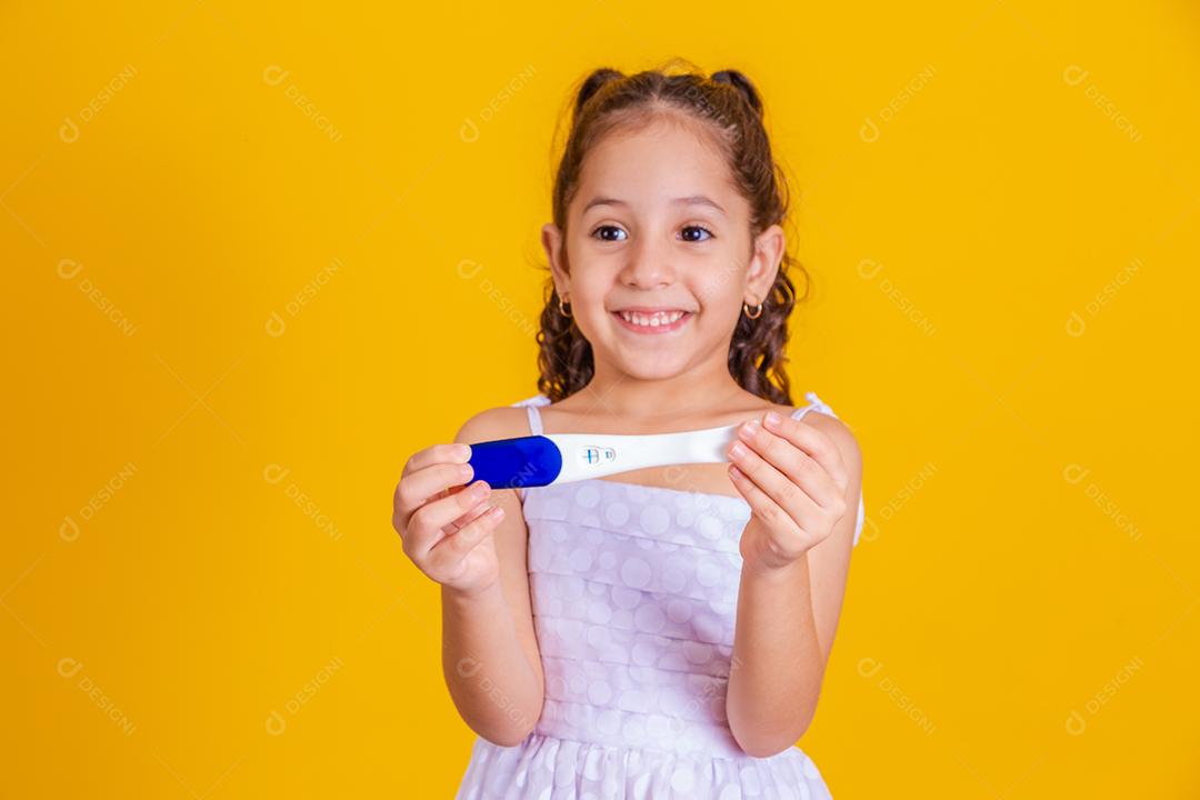 Retrato de menina adorável segurando teste de gravidez de sua mãe