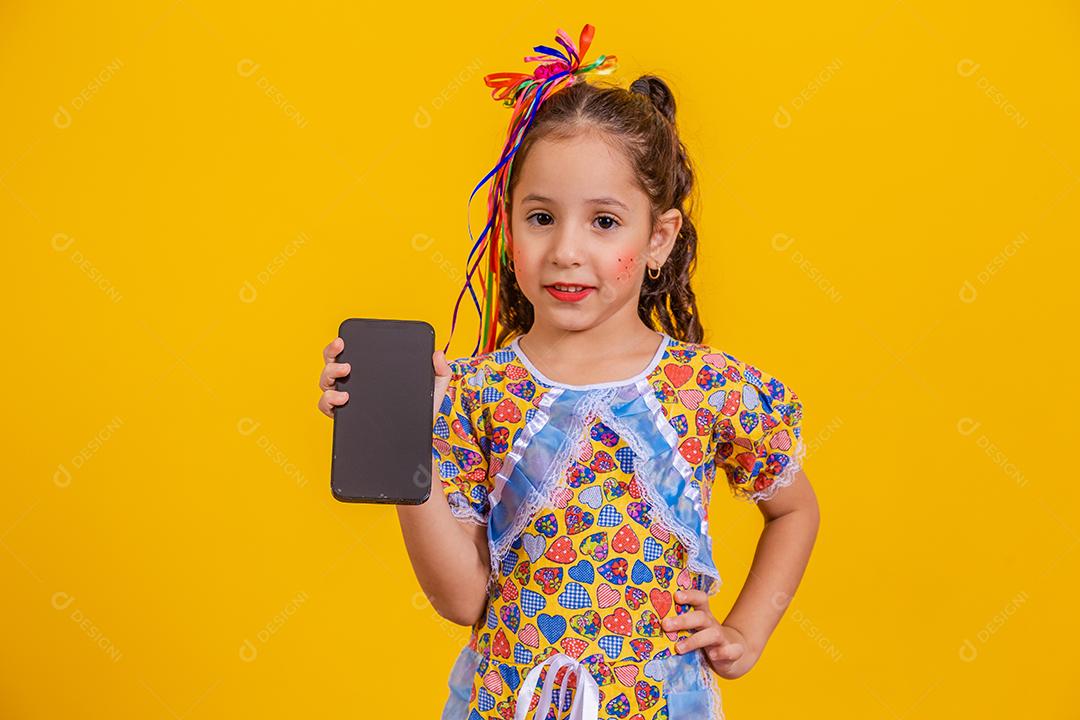 Menina bonitinha com roupa de festa segurando smartphone