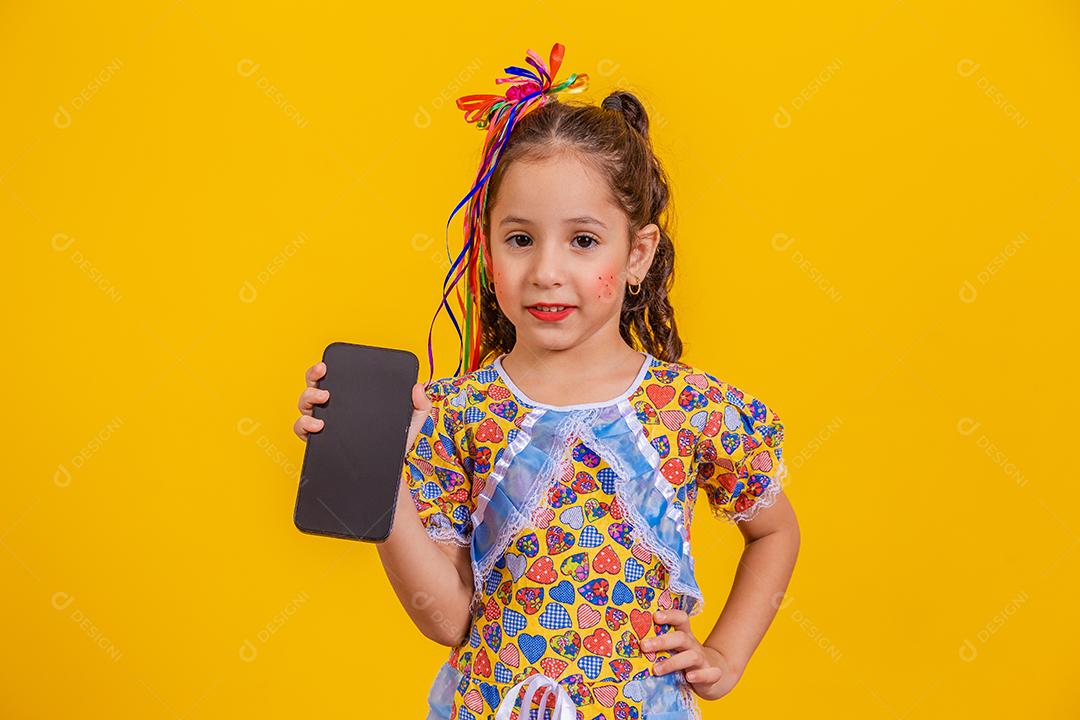 Menina bonitinha com roupa de festa segurando smartphone