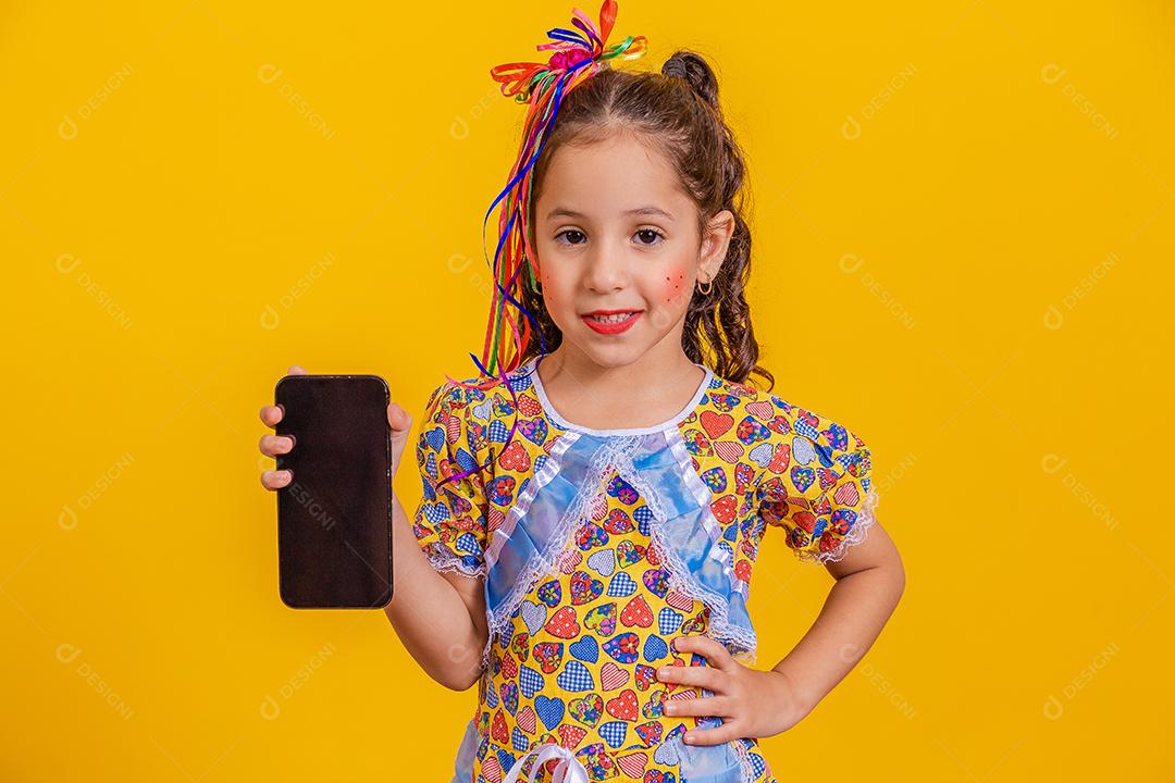 Menina bonitinha com roupa de festa segurando smartphone