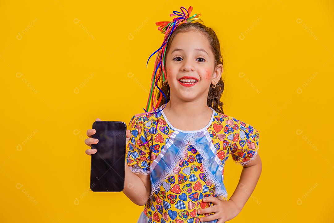 Menina bonitinha com roupa de festa segurando smartphone