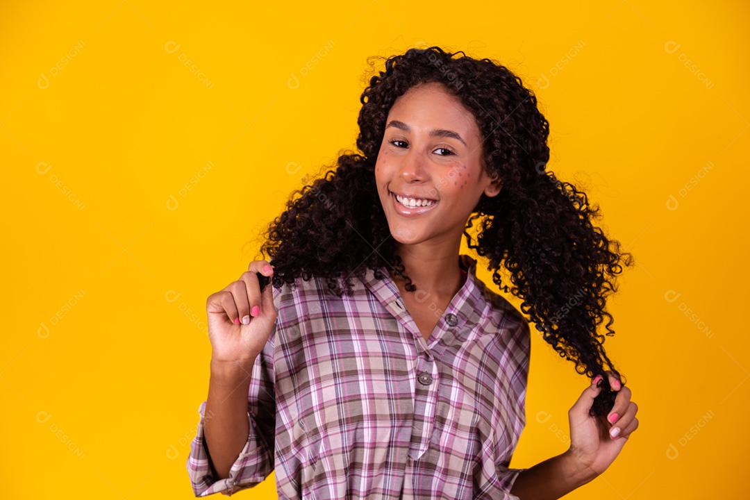 Mulher afro vestida com roupas de festa junina e cabelo amarrado por maria