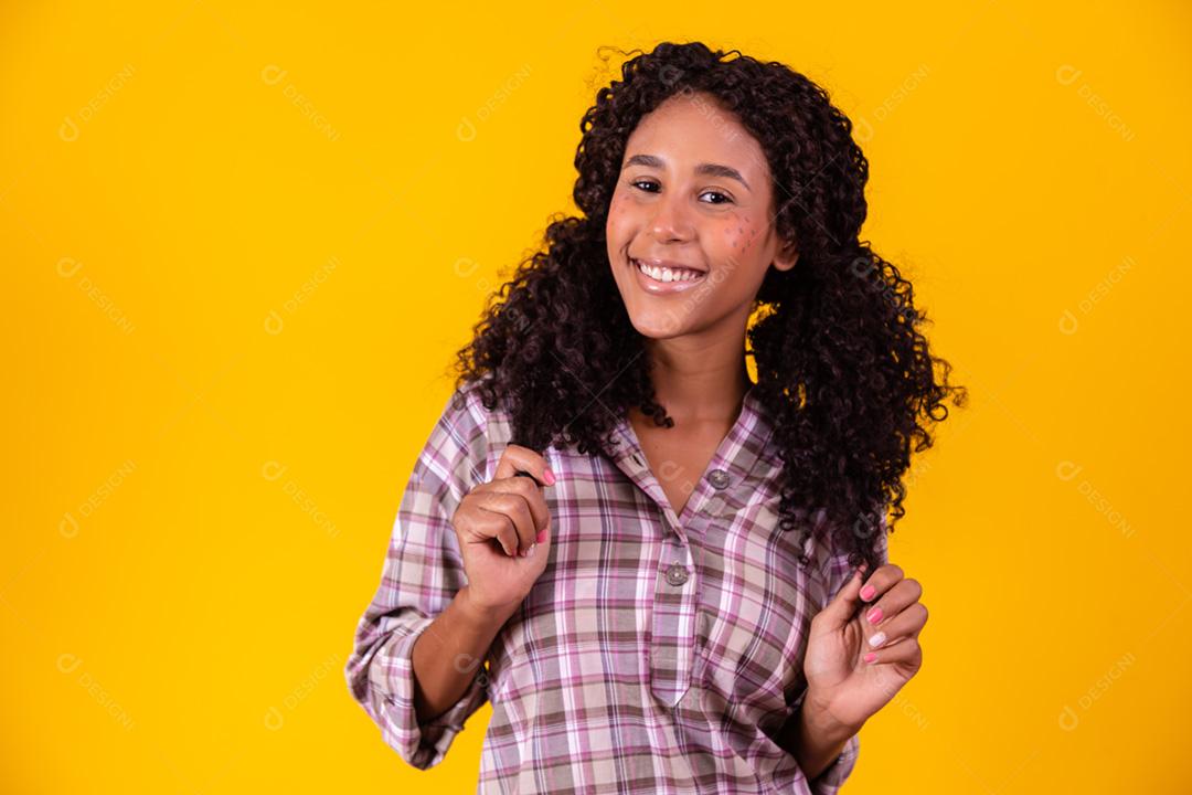 Mulher afro vestida com roupas de festa junina e cabelo amarrado por maria