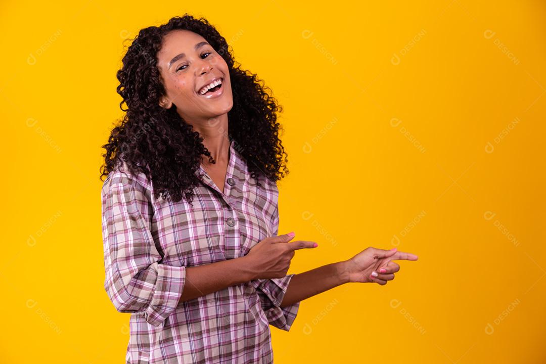 Mulher afro vestida com roupas de festa junina e cabelo amarrado por maria