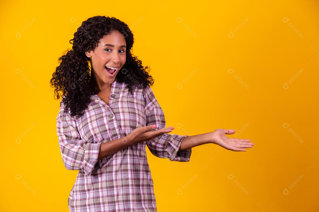 Mulher afro vestida com roupas de festa junina e cabelo amarrado por maria