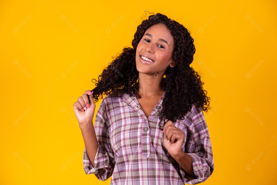 Mulher afro vestida com roupas de festa junina e cabelo amarrado por maria