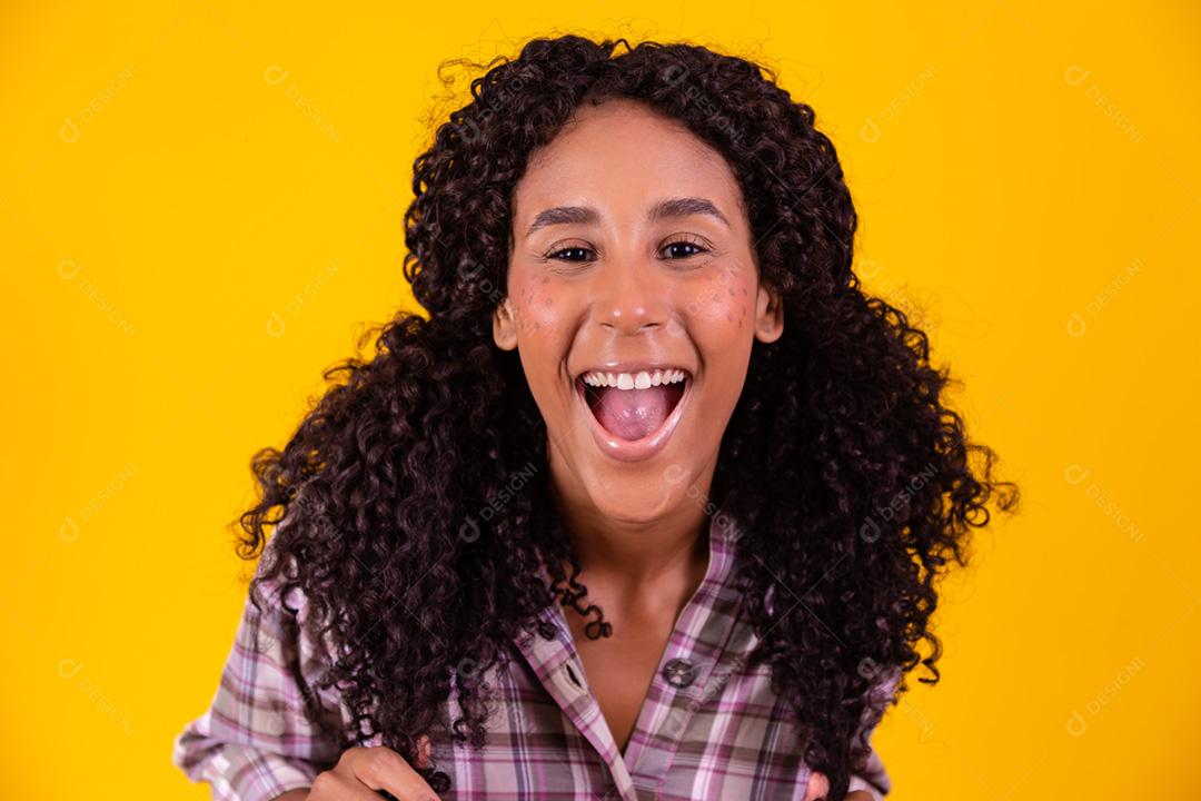 Mulher afro vestida com roupa de festa junina apontando para o lado.